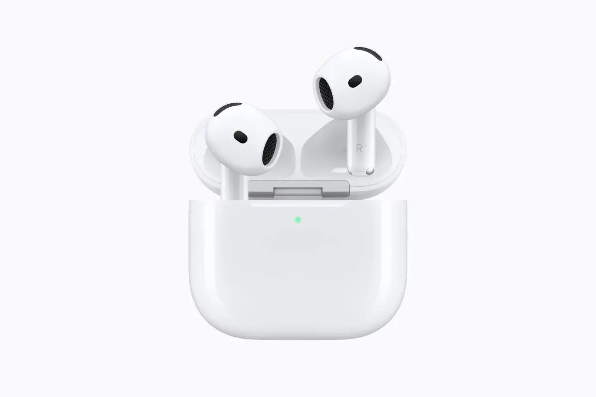 AirPods 5 blancos saliendo de su estuche de carga abierto, con la luz de estado en verde